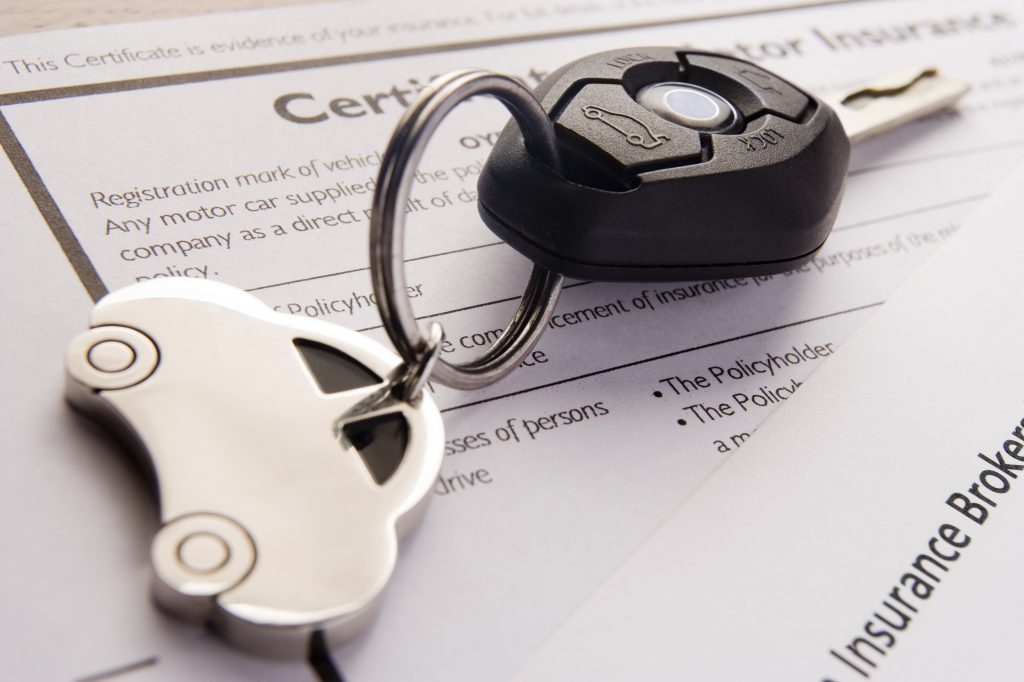 Car keys on car insurance certificate