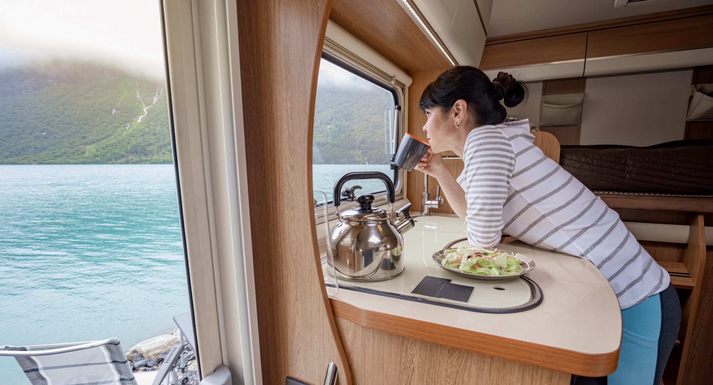 woman looking out of window of motorhome