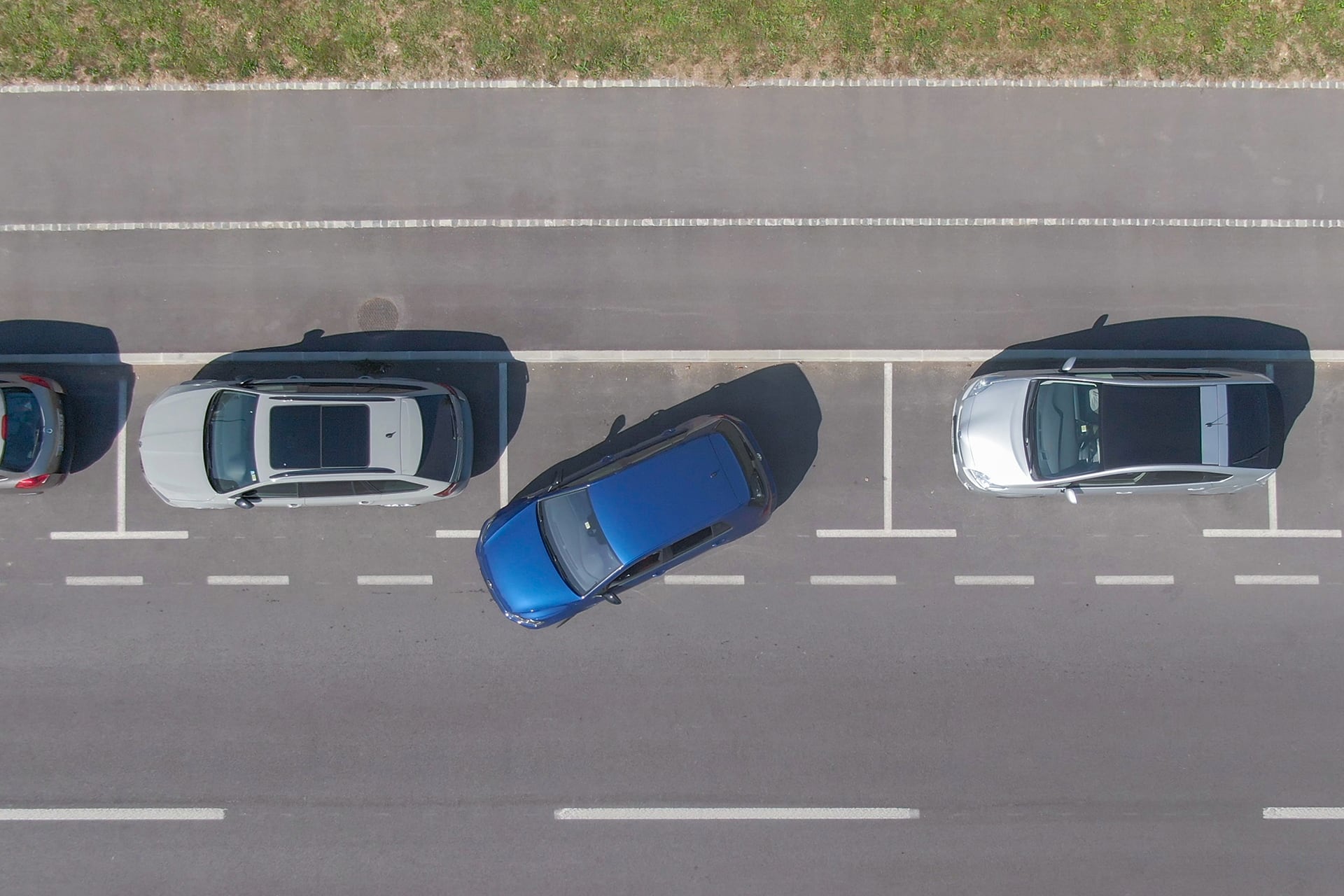 image of car reversing between two parked cars