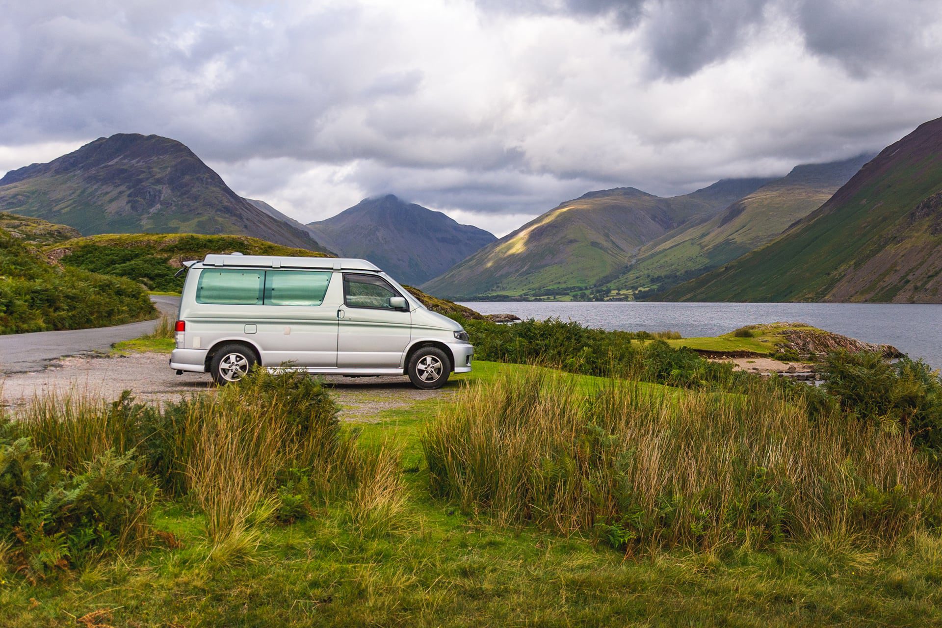 Camper van in front of lake and mountains