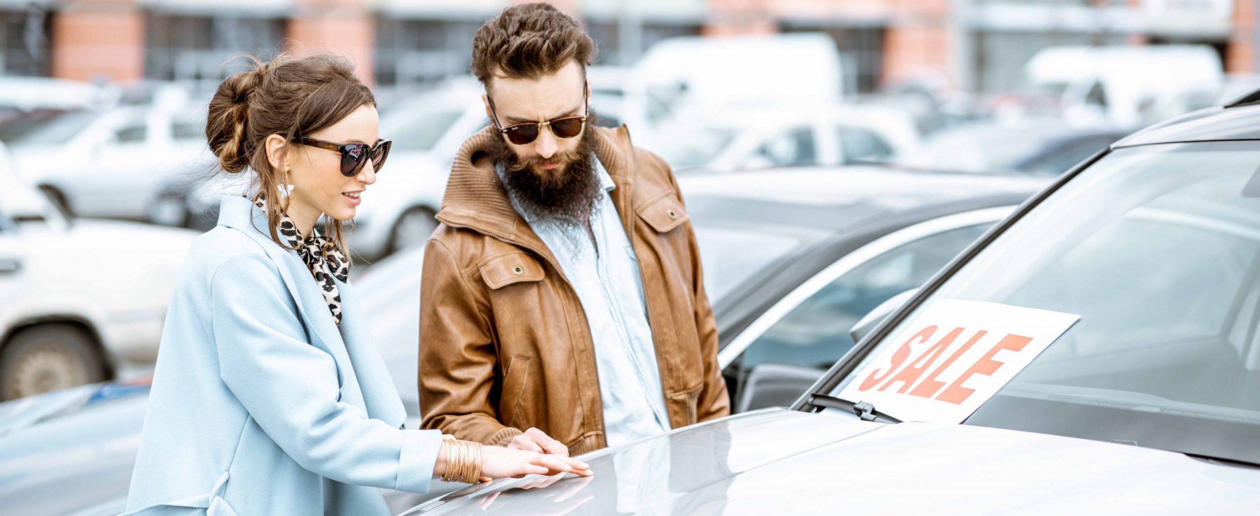 Man and woman choosing car to buy