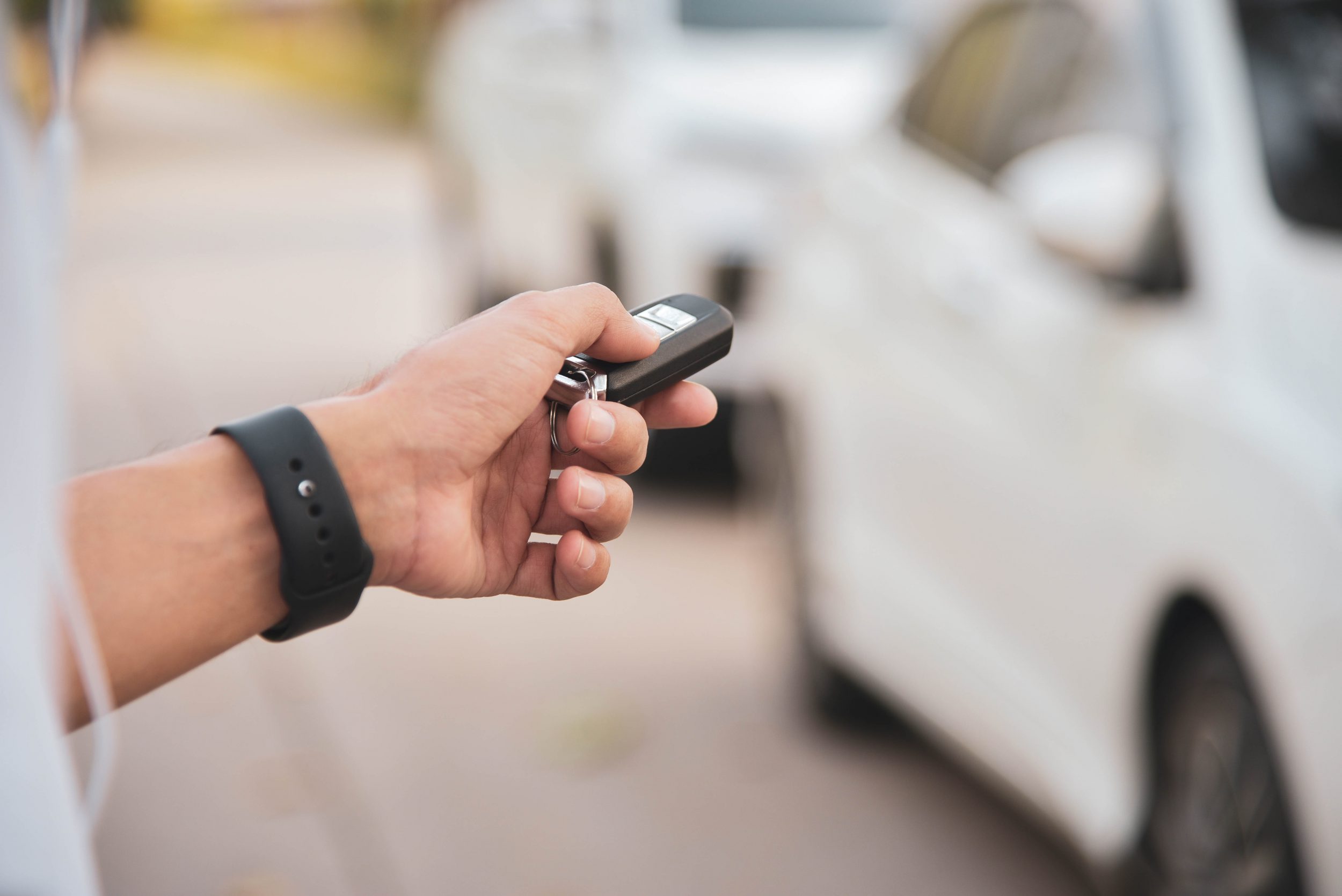 Man using key fob to open car